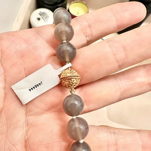 Saks fifth Avenue moon stone hand strung. New in duster. 14k gold plated clasp